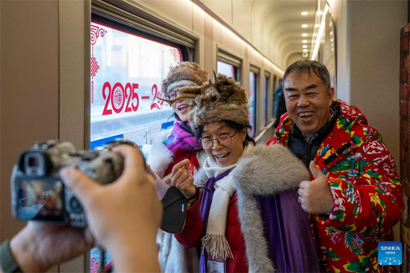 Des passagers posent pour des photos à bord du train Y783, dans la province du Heilongjiang (nord-est de la Chine), le 25 janvier 2026. (Zhang Tao/Xinhua)