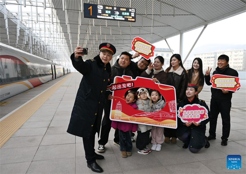 Les personnels ferroviaires et les passagers du train à grande vitesse G359 prennent des selfies sur le quai de la gare de Yan'an, dans la province du Shaanxi (nord-ouest de la Chine), le 26 janvier 2026. (Li Yibo/Xinhua)