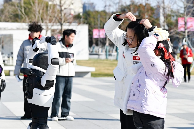 Des habitantes interagissent avec des robots sur une place de la ville de Kunshan, dans la province du Jiangsu (est de la Chine). (Photo/Yuan Xinyu)