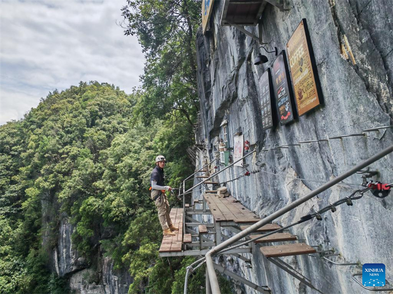 Un entraîneur effectue une ascension de via ferrata dans un café en falaise du comté de Libo, dans la province du Guizhou (sud-ouest de la Chine), le 11 juillet 2024. (Wu Si/Xinhua)