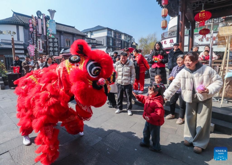 Des artistes de la danse du lion communiquent avec des touristes dans la vieille ville de Shouchang à Jiande, dans la province du Zhejiang (est de la Chine), le 8 février 2026. (Xu Yu / Xinhua)
