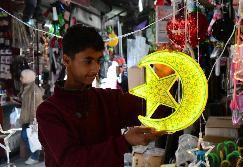 Un jeune homme admire les décorations du ramadan dans le vieux quartier de Damas, en Syrie, le 18 février 2026. (/Xinhua/Ammar Safarjalani)