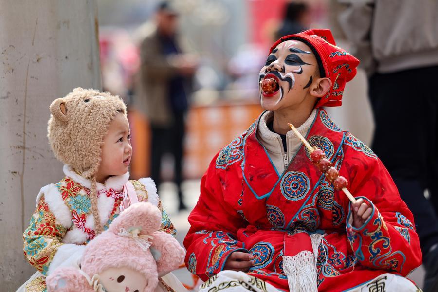 Un enfant interagit avec un artiste lors d'un spectacle de culture folklorique à Lanzhou, dans la province chinoise du Gansu (nord-ouest), le 18 février 2026. (Photo : Hou Chonghui)