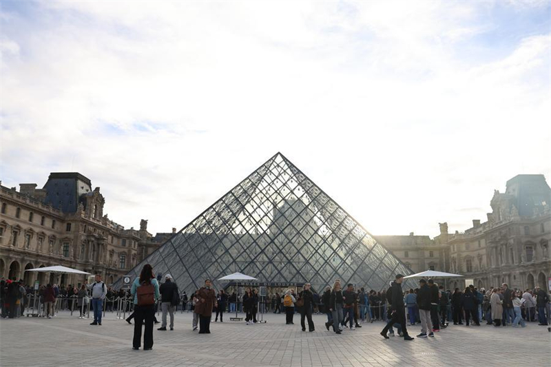 Des touristes devant la pyramide du Louvre à Paris, en France, le 22 octobre 2025. Le musée du Louvre a rouvert ses portes aux visiteurs ce matin-là, trois jours après un vol de bijoux qui a causé d'importantes pertes. (Xinhua/Zhang Baihui)