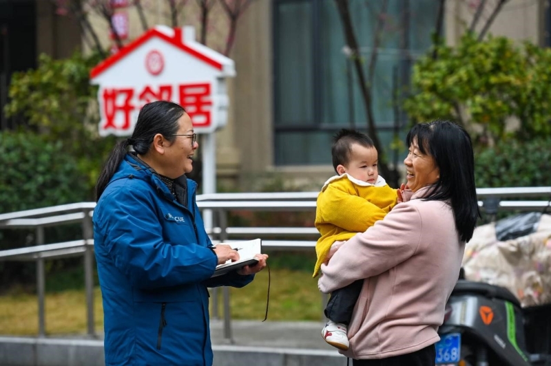 Un membre du Comité de la CCPPC de la ville de Yichun, dans la province du Jiangxi (est de la Chine) (à gauche) communique avec les habitants d'une communauté et écoute leurs opinions et suggestions, le 27 janvier. (Photo / Zhou Liang)