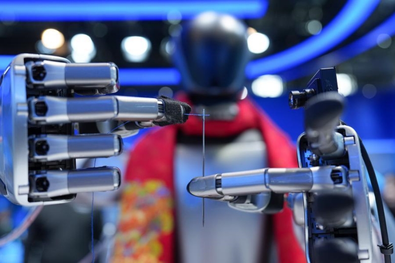 Un robot fait une démonstration de sa fonction d'enfilage d'aiguille lors d'une exposition permanente au centre d'exposition de Zhongguancun, à Beijing, capitale de la Chine, le 25 mars 2026. (Photo : Ju Huanzong)