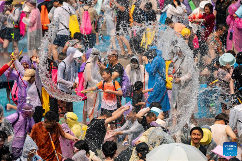 Des gens célèbrent le festival des éclaboussures d'eau sur une place de Jinghong, dans la préfecture autonome Dai du Xishuangbanna, dans la province du Yunnan (sud-ouest de la Chine), le 15 avril 2026. (Jiang Wenyao/Xinhua)