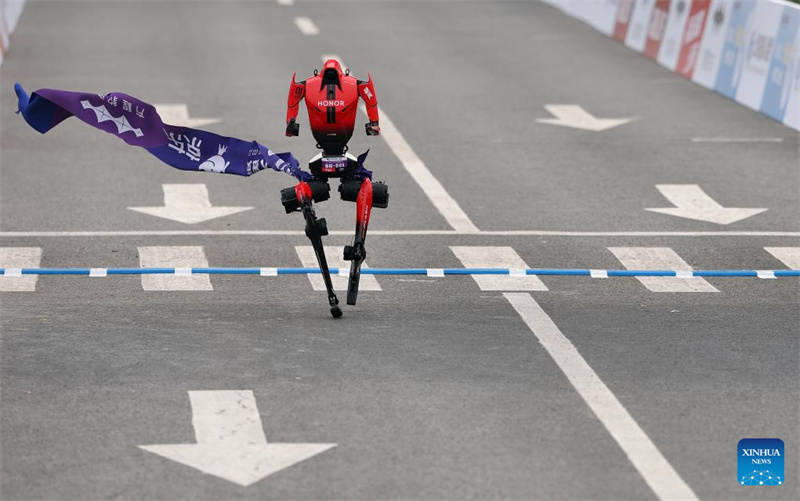 Le robot humanoïde « Flash » de l'équipe Pofengshandian de la catégorie télécommandée franchit la ligne d'arrivée lors du semi-marathon de l'E-Town de Beijing et du semi-marathon des robots humanoïdes dans la zone de développement économique et technologique de Beijing, dans le sud-est de Beijing, le 19 avril 2026. (Zhang Chenlin/Xinhua)