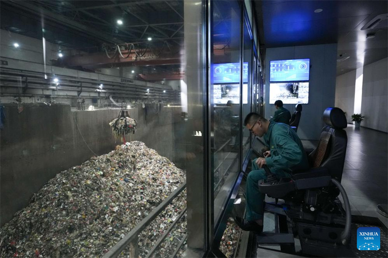 Des membres du personnel utilisent des bras mécaniques pour transporter des déchets vers l'incinérateur du parc de protection de l'environnement de Heimifeng, à Changsha, capitale de la province du Hunan (centre de la Chine), le 22 avril 2026. (Chen Zhenhai/Xinhua)
