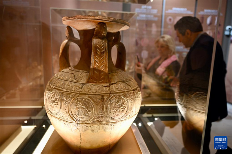 Des visiteurs observent des pièces exposées lors de l'exposition « La Symphonie des civilisations le long de la Route de la Soie » d'objets culturels et artistiques du Xinjiang (nord-ouest de la Chine), le 7 mai à Athènes. (Lv You/Xinhua)