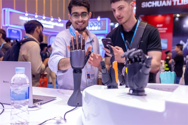 Des acheteurs étrangers interagissent avec des mains robotisées lors de la 139e édition de la Foire d'importation et d'exportation de Chine, plus connue sous le nom de Foire de Canton, le 17 avril à Guangzhou, capitale de la province du Guangdong (sud de la Chine). (Photo/Fu Haiyan)