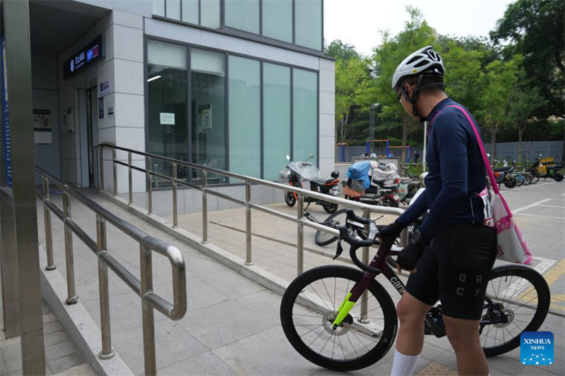 Un passager transportant un vélo entre dans la station Xitucheng du métro de Beijing, le 16 mai 2026. (Dai Mingxuan/Xinhua)