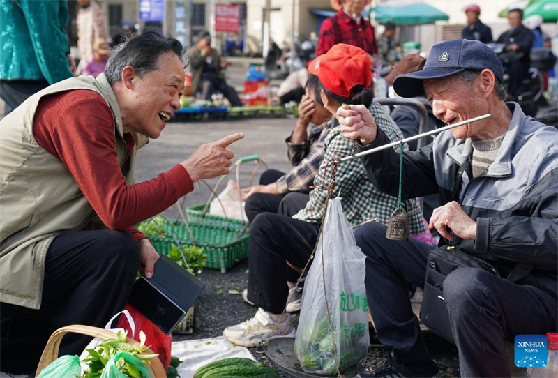 Un habitant achète des légumes à un agriculteur sur un « marché fluctuant » en bordure de route dans le district de Chaisang à Jiujiang, dans la province du Jiangxi (est de la Chine), le 12 mai 2026. (Wan Xiang/Xinhua)