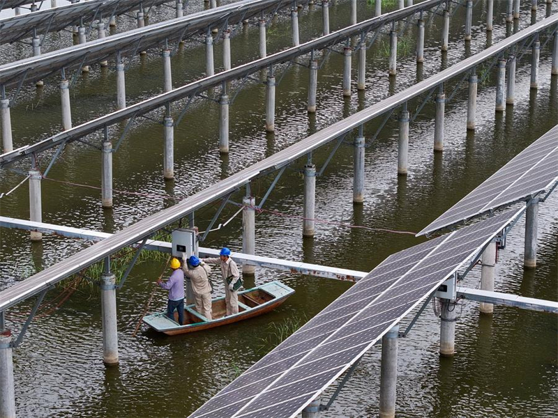 Photo prise par un drone de techniciens de la production d'électricité patrouillant dans un projet d'énergie photovoltaïque à Yangzhou, dans la province chinoise du Jiangsu (est), le 21 mai 2024. (Photo : Li Bo)
