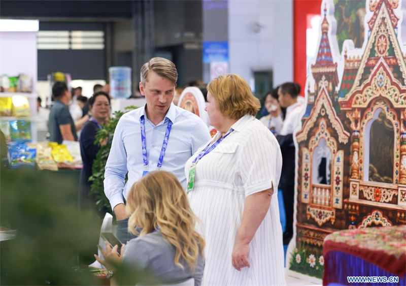 Des membres du personnel du stand de la Russie discutent lors de la 9e Exposition Chine-Eurasie, à Urumqi, capitale de la région autonome ouïgoure du Xinjiang, dans le nord-ouest de la Chine, le 25 juin 2026. (Photo : Wang Fei)