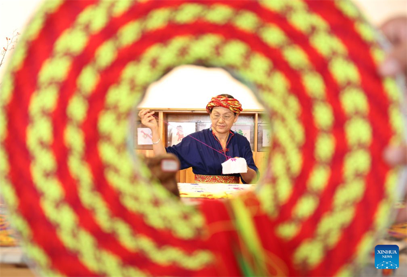 Une femme de la branche de Huayao du groupe ethnique Yao fabrique une broderie au point de croix Tiaohua dans le comté de Longhui à Shaoyang, dans la province du Hunan (centre de la Chine), le 23 juin 2026. (Zhao Zhongzhi/Xinhua)
