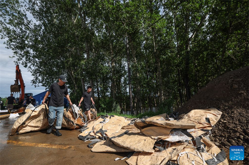Des secouristes remplissent des sacs de sable sur une digue du village de Yujiatai du district de Liaozhong, à Shenyang, capitale de la province du Liaoning (nord-est de la Chine), le 14 juillet 2026.  (Pan Yulong/Xinhua)
