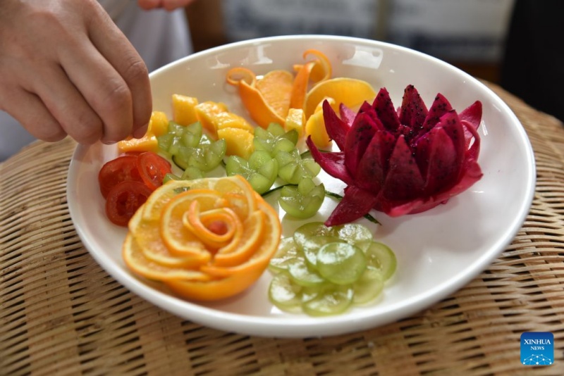 Un concurrent participe à une sculpture sur fruits lors d'un événement sur le thème des « saveurs villageoises » dans le comté de Shiqian de la ville de Tongren, dans la province du Guizhou (sud-ouest de la Chine), le 28 juin 2026. (Xinhua/Li Fan)
