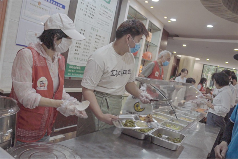 Des bénévoles aident à servir des repas aux résidents âgés dans un site de service de repas dans la communauté de Chunjiang, dans le district de Shangcheng à Hangzhou, capitale de la province du Zhejiang (est de la Chine), le 12 juin 2026. (Zhang Rong/Le Quotidien du Peuple en ligne)